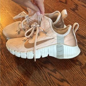 Light pink and rose gold Nike Metcon sneakers